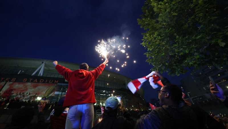 Para penggemar Arsenal merayakan kemenangan di luar stadion Emirates saat Arsenal memenangkan Liga Inggris di London, Inggris, Selasa (19/4/2026) malam waktu setempat. (Action Images via Reuters/Andrew Boyers)