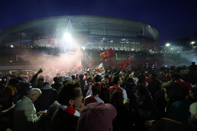 Para penggemar Arsenal merayakan kemenangan di luar stadion Emirates saat Arsenal memenangkan Liga Inggris di London, Inggris, Selasa (19/4/2026) malam waktu setempat. (Action Images via Reuters/Andrew Boyers)
