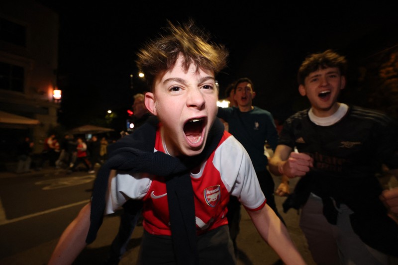 Para penggemar Arsenal merayakan kemenangan di luar stadion Emirates saat Arsenal memenangkan Liga Inggris di London, Inggris, Selasa (19/4/2026) malam waktu setempat. (Action Images via Reuters/Andrew Boyers)