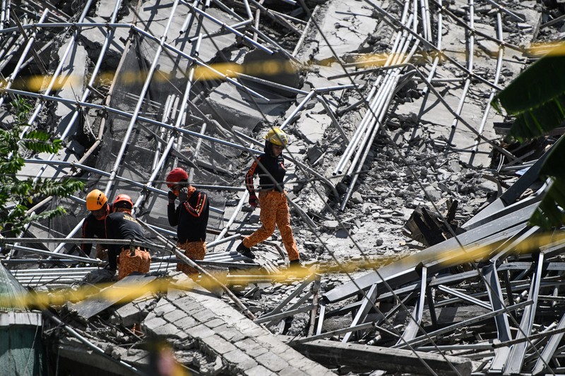 Petugas keselamatan tiba dilokasi bangunan yang sedang dalam proses pembangunan di Filipina roboh pada Minggu (24/5/2026) pagi. (REUTERS/Noel Celis)
