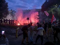 A group of demonstrators clash with riot police outside Serbia's parliament building during clashes that erupt at the end of an anti-government protest decrying corruption and calling for early elections following the collapse of a railway station ca