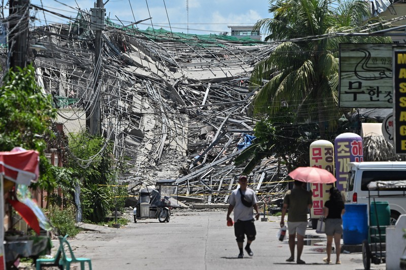 Petugas penyelamat mencari korban selamat di antara reruntuhan saat sebuah gedung sembilan lantai yang sedang dibangun runtuh di Balibago, Angeles City, Pampanga, Filipina, 24 Mei 2026. (REUTERS/Noel Celis)
