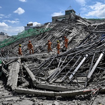Petugas penyelamat mencari korban selamat di antara reruntuhan saat sebuah gedung sembilan lantai yang sedang dibangun runtuh di Balibago, Angeles City, Pampanga, Filipina, 24 Mei 2026. (REUTERS/Noel Celis)