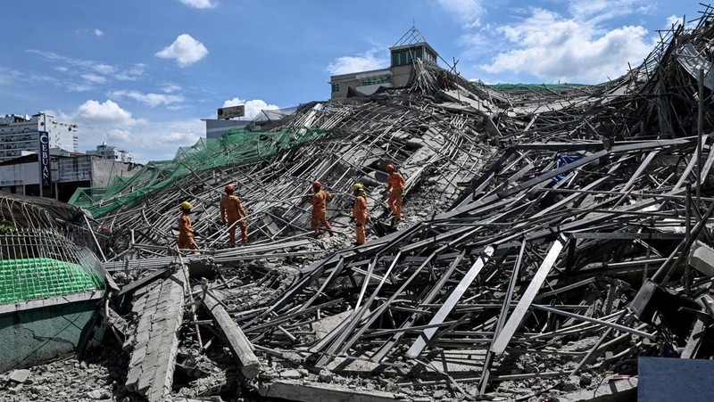 Petugas penyelamat mencari korban selamat di antara reruntuhan saat sebuah gedung sembilan lantai yang sedang dibangun runtuh di Balibago, Angeles City, Pampanga, Filipina, 24 Mei 2026. (REUTERS/Noel Celis)
