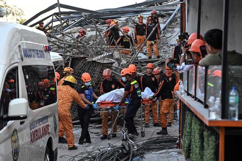 Petugas penyelamat mencari korban selamat di antara reruntuhan saat sebuah gedung sembilan lantai yang sedang dibangun runtuh di Balibago, Angeles City, Pampanga, Filipina, 24 Mei 2026. (REUTERS/Noel Celis)