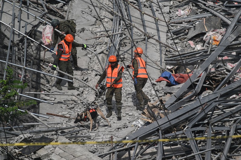 Petugas penyelamat mencari korban selamat di antara reruntuhan saat sebuah gedung sembilan lantai yang sedang dibangun runtuh di Balibago, Angeles City, Pampanga, Filipina, 24 Mei 2026. (REUTERS/Noel Celis)