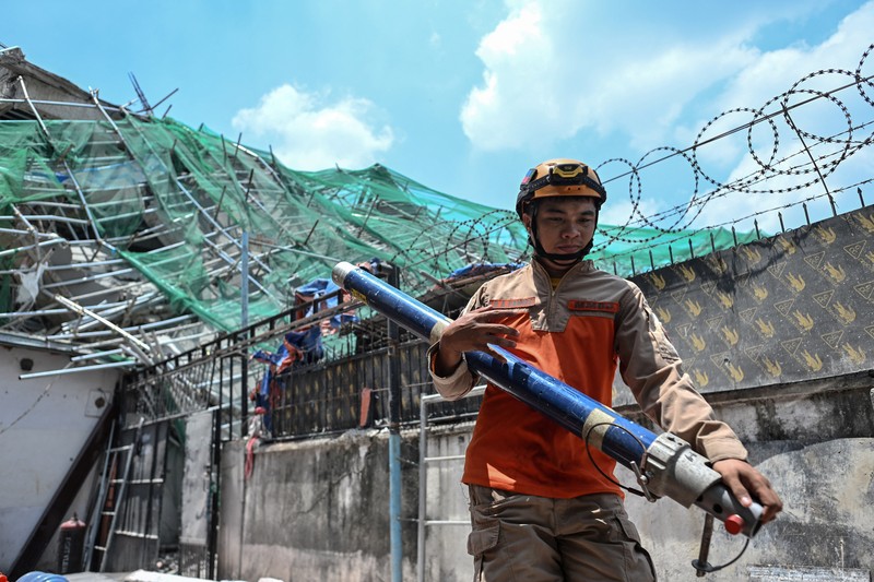 Petugas penyelamat mencari korban selamat di antara reruntuhan saat sebuah gedung sembilan lantai yang sedang dibangun runtuh di Balibago, Angeles City, Pampanga, Filipina, 24 Mei 2026. (REUTERS/Noel Celis)