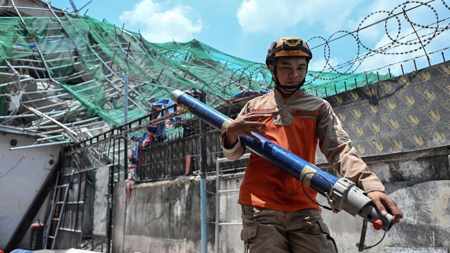 Seorang petugas penyelamat membawa peralatan saat ia mencari korban selamat yang terjebak di antara reruntuhan bangunan sembilan lantai yang runtuh di Balibago, Angeles City, Pampanga, Filipina, 25 Mei 2026.