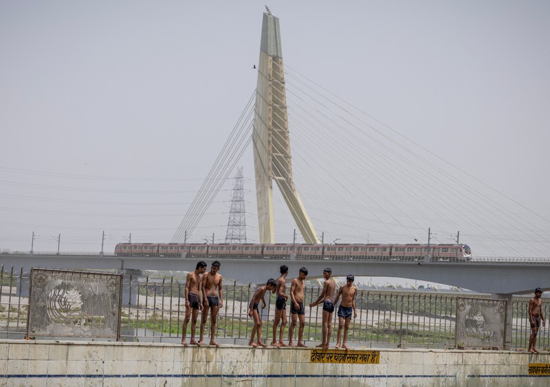 Orang-orang berenang di kolam renang umum pada hari musim panas yang terik di New Delhi, India, 25 Mei 2026. (REUTERS/Adnan Abidi)