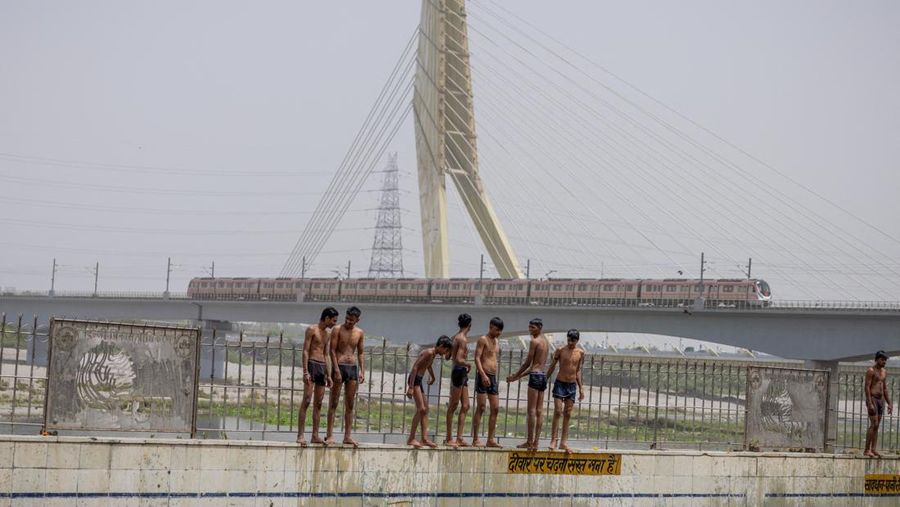 Anak-anak laki-laki bersiap untuk melompat di kolam renang umum pada hari musim panas yang terik di New Delhi, India, 25 Mei 2026.