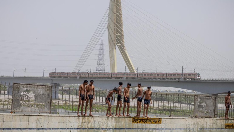 Anak-anak laki-laki bersiap untuk melompat di kolam renang umum pada hari musim panas yang terik di New Delhi, India, 25 Mei 2026.
