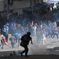 A police officer runs in front of demonstrators during a march calling for the resignation of Bolivian President Rodrigo Paz, as the country’s economic and fuel crisis worsens due to a shortage of U.S. dollars and declining domestic energy producti