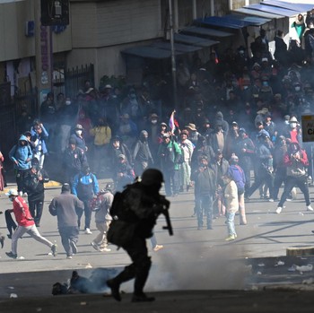 A police officer runs in front of demonstrators during a march calling for the resignation of Bolivian President Rodrigo Paz, as the country’s economic and fuel crisis worsens due to a shortage of U.S. dollars and declining domestic energy producti