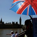Tourists walk past a souvenir vendor in front of Big Ben during a heatwave as the UK experienced record temperatures for the month of May in London, Britain, May 25, 2026. REUTERS/Kevin Coombs     TPX IMAGES OF THE DAY