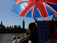 Tourists walk past a souvenir vendor in front of Big Ben during a heatwave as the UK experienced record temperatures for the month of May in London, Britain, May 25, 2026. REUTERS/Kevin Coombs     TPX IMAGES OF THE DAY