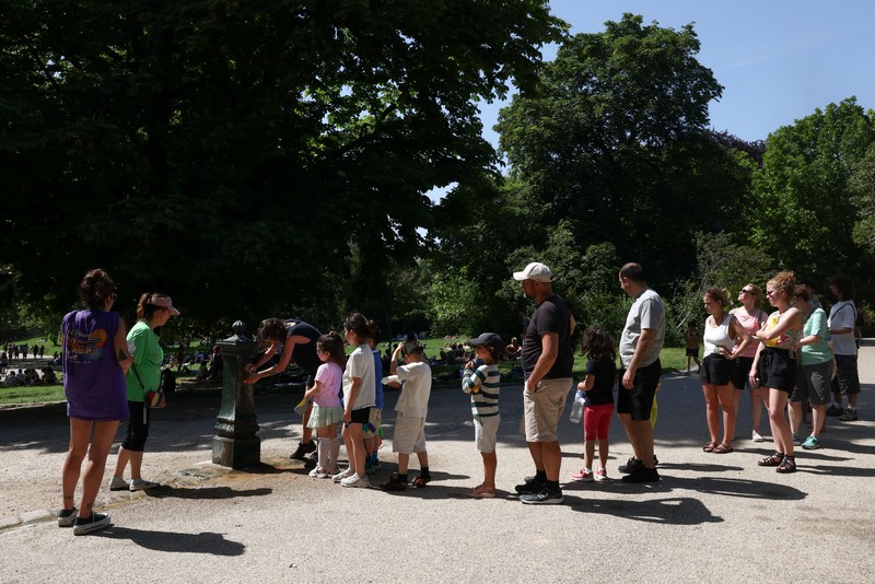 A worker sprays water on people passing by in Buttes Chaumont park, as temperatures reached up to 35 degrees Celsius, during a period of hot weather in Paris, France, May 25, 2026. REUTERS/Tom Nicholson