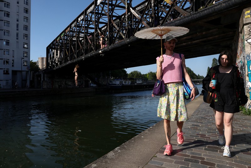 A worker sprays water on people passing by in Buttes Chaumont park, as temperatures reached up to 35 degrees Celsius, during a period of hot weather in Paris, France, May 25, 2026. REUTERS/Tom Nicholson