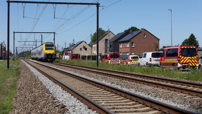 Kendaraan darurat beroperasi di dekat lokasi kejadian di mana sebuah bus sekolah ditabrak kereta api di perlintasan sebidang yang menyebabkan banyak korban jiwa, dekat kota Buggenhout, Belgia, 26 Mei 2026.