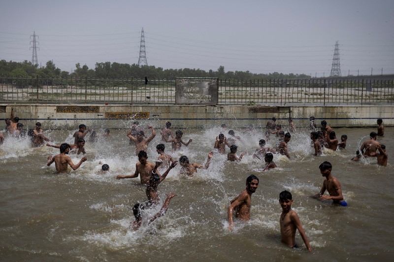 Orang-orang berenang di kolam renang umum pada hari musim panas yang terik di New Delhi, India, 25 Mei 2026. (REUTERS/Adnan Abidi)