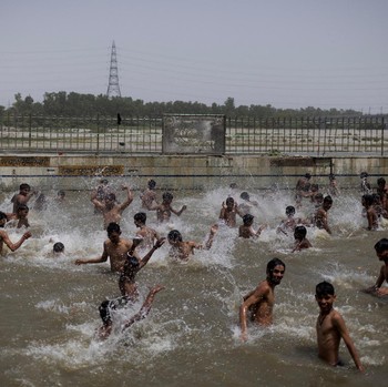Orang-orang berenang di kolam renang umum pada hari musim panas yang terik di New Delhi, India, 25 Mei 2026. (REUTERS/Adnan Abidi)
