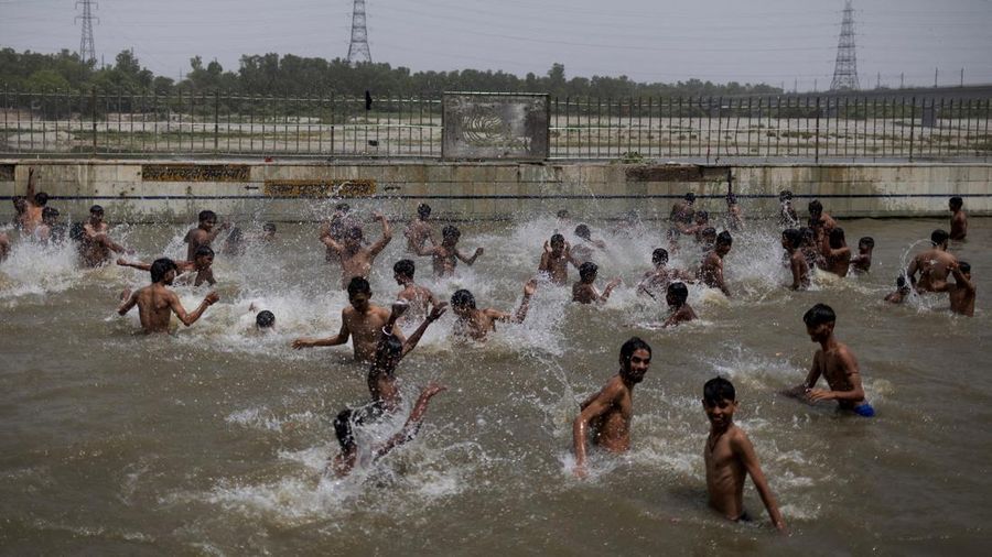 Orang-orang berenang di kolam renang umum pada hari musim panas yang terik di New Delhi, India, 25 Mei 2026. (REUTERS/Adnan Abidi)