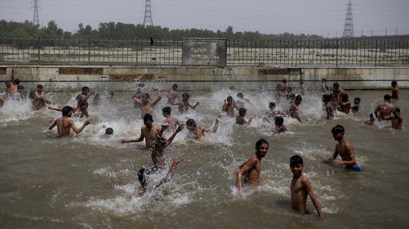 Orang-orang berenang di kolam renang umum pada hari musim panas yang terik di New Delhi, India, 25 Mei 2026. (REUTERS/Adnan Abidi)