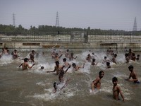 Orang-orang berenang di kolam renang umum pada hari musim panas yang terik di New Delhi, India, 25 Mei 2026. (REUTERS/Adnan Abidi)