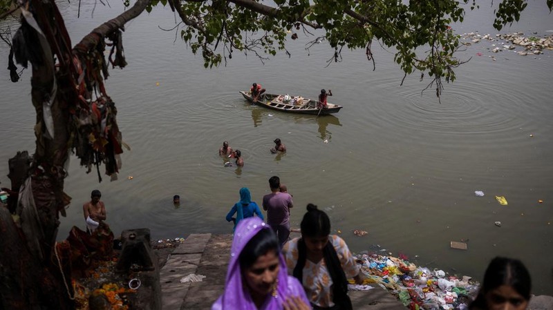 Orang-orang mandi di perairan sungai Yamuna pada hari musim panas yang terik di New Delhi, India, 25 Mei 2026.