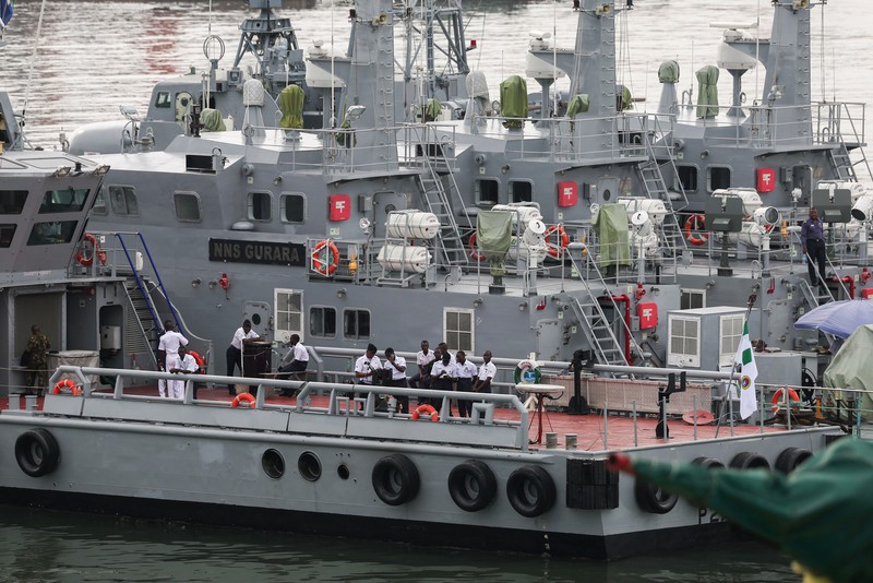 Para tamu menyaksikan anggota Unit Penerbangan Angkatan Laut Nigeria dan Layanan Perahu Khusus melakukan latihan di samping NNS Kada, kapal operasional terbesar angkatan laut, selama latihan di luar pelabuhan yang menandai peringatan 70 tahun angkatan laut di sepanjang garis pantai Atlantik di Lagos, Nigeria, 25 Mei 2026. (REUTERS/Sodiq Adelakun)