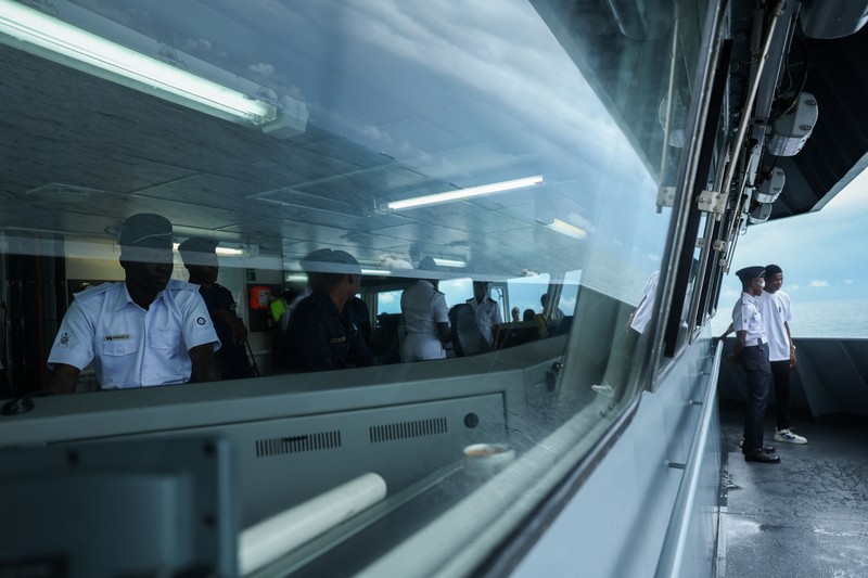 Para tamu menyaksikan anggota Unit Penerbangan Angkatan Laut Nigeria dan Layanan Perahu Khusus melakukan latihan di samping NNS Kada, kapal operasional terbesar angkatan laut, selama latihan di luar pelabuhan yang menandai peringatan 70 tahun angkatan laut di sepanjang garis pantai Atlantik di Lagos, Nigeria, 25 Mei 2026. (REUTERS/Sodiq Adelakun)
