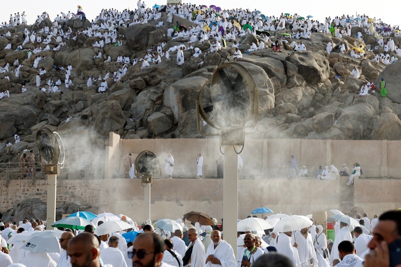 Para peziarah Muslim menggunakan payung untuk melindungi diri dari terik matahari setelah salat Zuhur di luar Masjid Nimrah di Dataran Arafat selama ibadah haji tahunan, di luar kota suci Mekah, Arab Saudi, 26 Mei 2026. (REUTERS/Ibraheem Abu Mustafa)