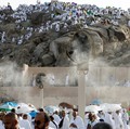 Para peziarah Muslim berkumpul di dekat kipas pengembun di Gunung Rahmat di dataran Arafat selama ibadah haji tahunan, di luar kota suci Mekah, Arab Saudi, 26 Mei 2026. (REUTERS/Ibraheem Abu Mustafa)