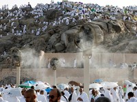 Para peziarah Muslim berkumpul di dekat kipas pengembun di Gunung Rahmat di dataran Arafat selama ibadah haji tahunan, di luar kota suci Mekah, Arab Saudi, 26 Mei 2026. (REUTERS/Ibraheem Abu Mustafa)