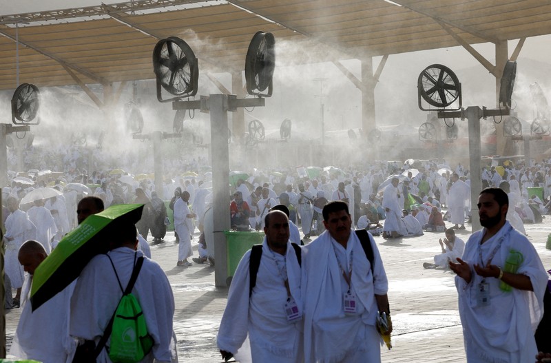 Para peziarah Muslim menggunakan payung untuk melindungi diri dari terik matahari setelah salat Zuhur di luar Masjid Nimrah di Dataran Arafat selama ibadah haji tahunan, di luar kota suci Mekah, Arab Saudi, 26 Mei 2026. (REUTERS/Ibraheem Abu Mustafa)