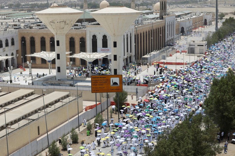 Para peziarah Muslim menggunakan payung untuk melindungi diri dari terik matahari setelah salat Zuhur di luar Masjid Nimrah di Dataran Arafat selama ibadah haji tahunan, di luar kota suci Mekah, Arab Saudi, 26 Mei 2026. (REUTERS/Ibraheem Abu Mustafa)