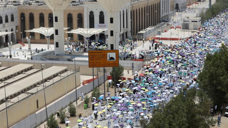 Para peziarah Muslim menggunakan payung untuk melindungi diri dari terik matahari pada hari salat Zuhur di luar Masjid Nimrah di Dataran Arafat selama ibadah haji tahunan, di luar kota suci Mekah, Arab Saudi, 26 Mei 2026.