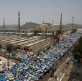 Para peziarah Muslim menggunakan payung untuk melindungi diri dari terik matahari setelah salat Zuhur di luar Masjid Nimrah di Dataran Arafat selama ibadah haji tahunan, di luar kota suci Mekah, Arab Saudi, 26 Mei 2026. (REUTERS/Ibraheem Abu Mustafa)