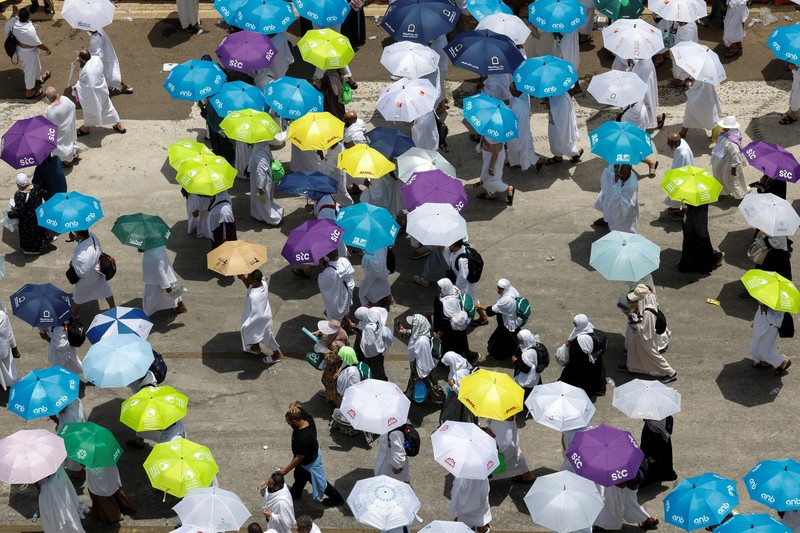 Para peziarah Muslim menggunakan payung untuk melindungi diri dari terik matahari setelah salat Zuhur di luar Masjid Nimrah di Dataran Arafat selama ibadah haji tahunan, di luar kota suci Mekah, Arab Saudi, 26 Mei 2026. (REUTERS/Ibraheem Abu Mustafa)