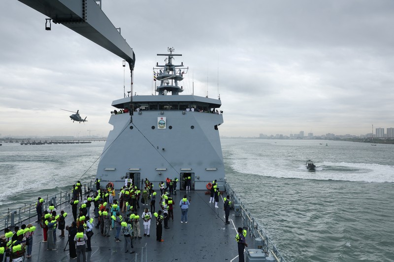 Para tamu menyaksikan anggota Unit Penerbangan Angkatan Laut Nigeria dan Layanan Perahu Khusus melakukan latihan di samping NNS Kada, kapal operasional terbesar angkatan laut, selama latihan di luar pelabuhan yang menandai peringatan 70 tahun angkatan laut di sepanjang garis pantai Atlantik di Lagos, Nigeria, 25 Mei 2026. (REUTERS/Sodiq Adelakun)