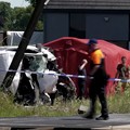 Tim penyelamat melihat bus sekolah yang rusak usai tertabrak kereta di sebuah perlintasan rel di wilayah Flanders utara, Beglia Selasa (26/5/2026) pagi waktu setempat. (Tangkapan Layar Video Reuters/)