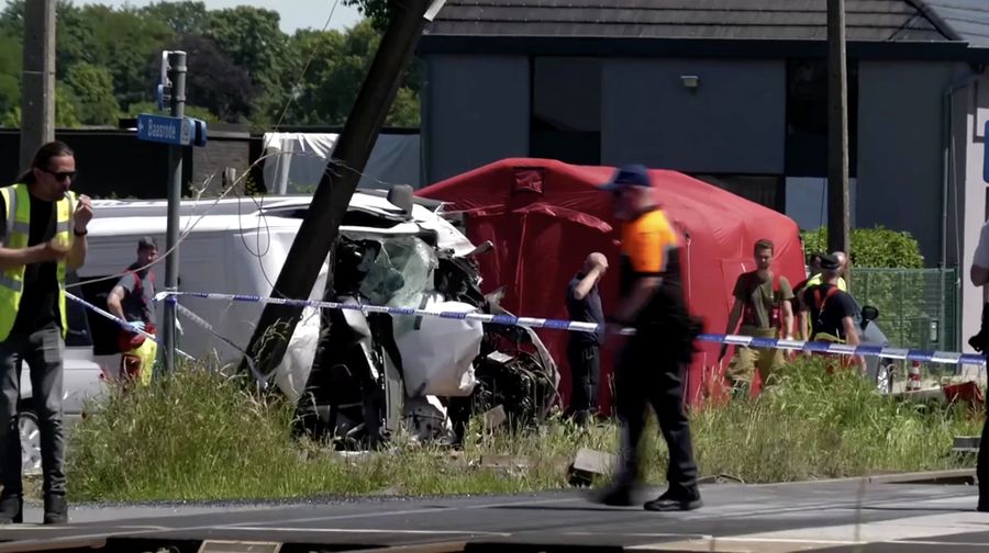 Tim penyelamat melihat bus sekolah yang rusak usai tertabrak kereta di sebuah perlintasan rel di wilayah Flanders utara, Beglia Selasa (26/5/2026) pagi waktu setempat. (Tangkapan Layar Video Reuters/)