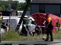Tim penyelamat melihat bus sekolah yang rusak usai tertabrak kereta di sebuah perlintasan rel di wilayah Flanders utara, Beglia Selasa (26/5/2026) pagi waktu setempat. (Tangkapan Layar Video Reuters/)