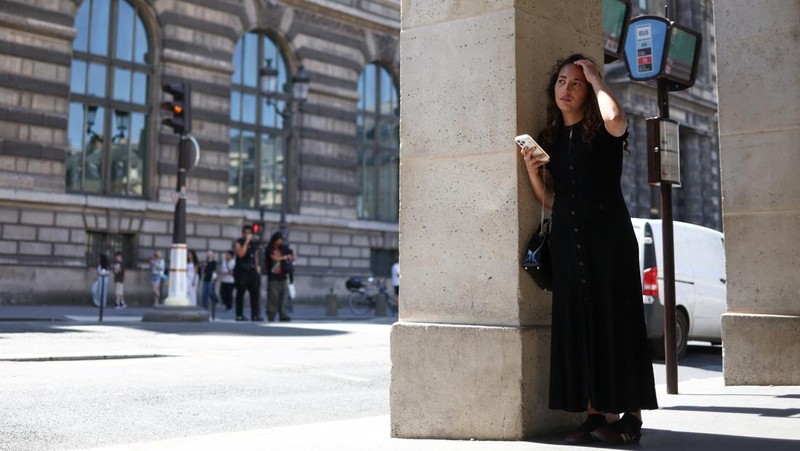 A person shelters from the sun on a street outside the Louvre amid a heatwave in Paris, France, May 27, 2026. REUTERS/Tom Nicholson