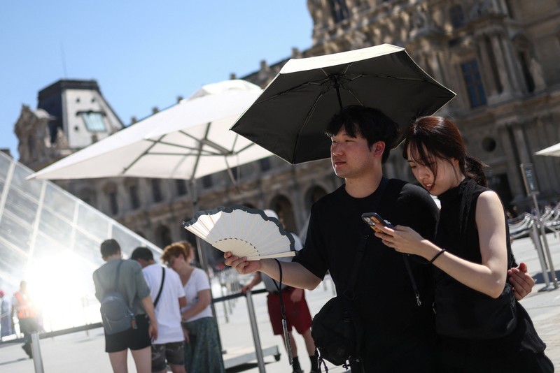 A woman with an umbrella walks at Plaza Puerta del Sol during a spring heatwave in Madrid, Spain, May 27, 2026. REUTERS/Kacper Pempel