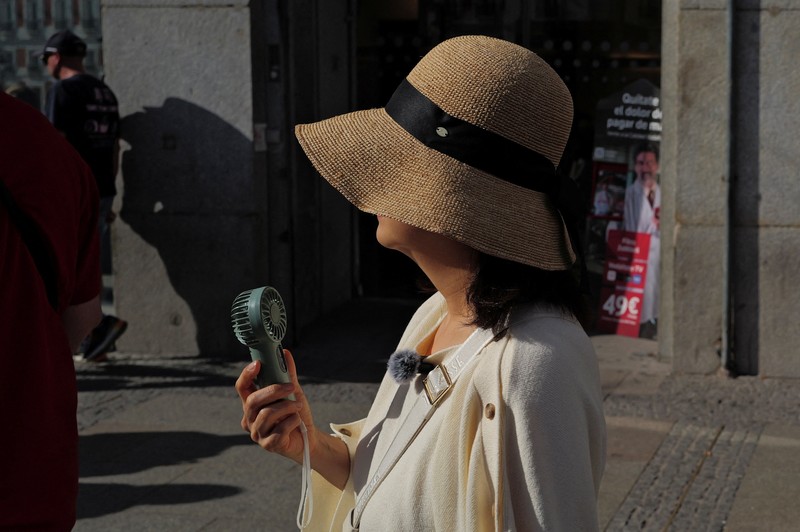 A woman with an umbrella walks at Plaza Puerta del Sol during a spring heatwave in Madrid, Spain, May 27, 2026. REUTERS/Kacper Pempel