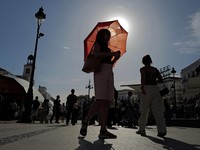 A woman with an umbrella walks at Plaza Puerta del Sol during a spring heatwave in Madrid, Spain, May 27, 2026. REUTERS/Kacper Pempel