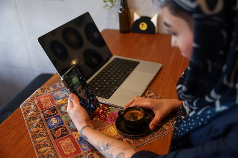 An Iranian woman works on a laptop in a cafe, after a reported reopening of international internet access, in Tehran, Iran, May 27, 2026. Majid Asgaripour/WANA (West Asia News Agency) via REUTERS ATTENTION EDITORS - THIS PICTURE WAS PROVIDED BY A THIRD PARTY. ISRAEL OUT. NO COMMERCIAL OR EDITORIAL SALES IN ISRAEL. NO USE BBC PERSIAN. NO USE VOA PERSIAN. NO USE MANOTO. NO USE IRAN INTERNATIONAL. NO USE RADIO FARDA. DIGITAL: NO USE BBC PERSIAN. NO USE VOA PERSIAN. NO USE MANOTO. NO USE IRAN INTERNATIONAL. NO USE RADIO FARDA. NO USE ISRAEL.