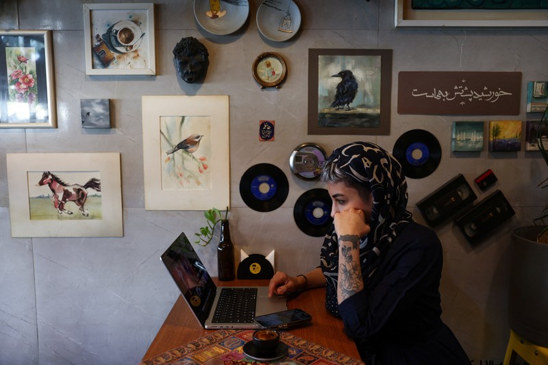 An Iranian woman works on a laptop in a cafe, after a reported reopening of international internet access, in Tehran, Iran, May 27, 2026. Majid Asgaripour/WANA (West Asia News Agency) via REUTERS ATTENTION EDITORS - THIS PICTURE WAS PROVIDED BY A THIRD PARTY. ISRAEL OUT. NO COMMERCIAL OR EDITORIAL SALES IN ISRAEL. NO USE BBC PERSIAN. NO USE VOA PERSIAN. NO USE MANOTO. NO USE IRAN INTERNATIONAL. NO USE RADIO FARDA. DIGITAL: NO USE BBC PERSIAN. NO USE VOA PERSIAN. NO USE MANOTO. NO USE IRAN INTERNATIONAL. NO USE RADIO FARDA. NO USE ISRAEL.