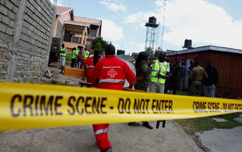 Members of the Kenya Red Cross walk towards the ruins of a burnt dormitory at the Utumishi Girls' Academy Senior School following an overnight fire at the facility in Gilgil, Nakuru county, Kenya May 28, 2026. REUTERS/Thomas Mukoya