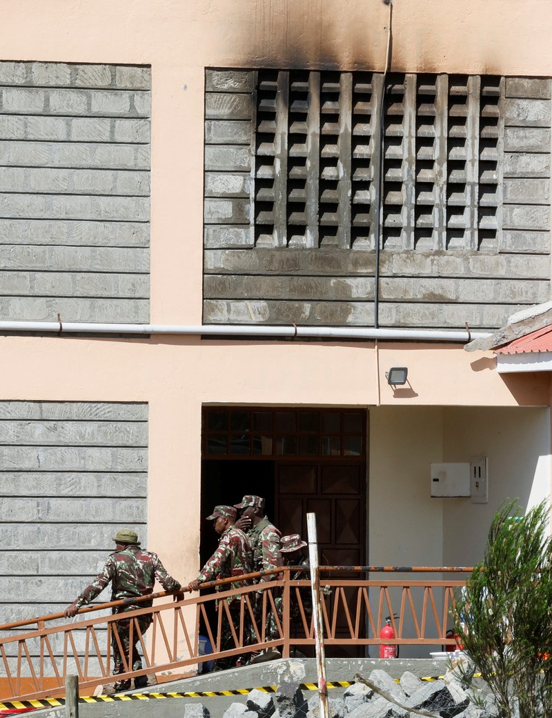 Members of the Kenya Red Cross walk towards the ruins of a burnt dormitory at the Utumishi Girls' Academy Senior School following an overnight fire at the facility in Gilgil, Nakuru county, Kenya May 28, 2026. REUTERS/Thomas Mukoya